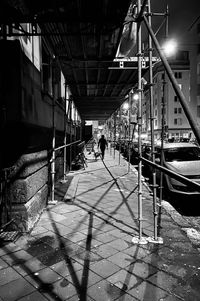 People walking on footpath by street in city