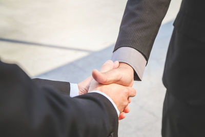 Close-up of business colleagues shaking hands outdoors