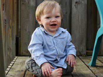 Portrait of smiling baby boy sitting outdoors
