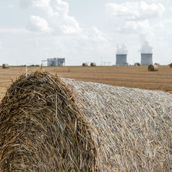 Hay bales on field against sky