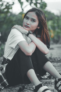 Portrait of young woman sitting outdoors