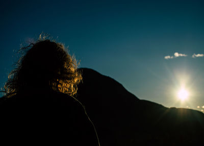 Rear view of silhouette woman against sky during sunset