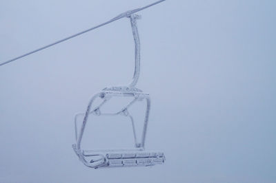 Low angle view of frozen hanging against sky