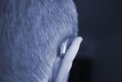 Close-up of man with hearing aid on black background