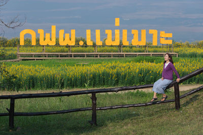 Full length of woman sitting on field