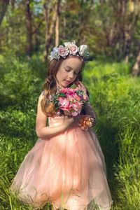 Girl holding flowers on field