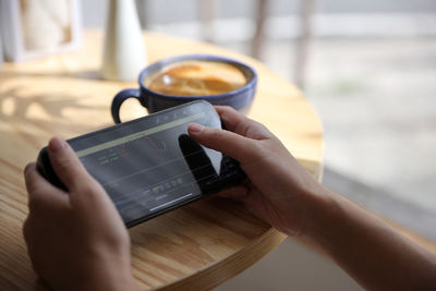 Cropped hands of woman using mobile phone