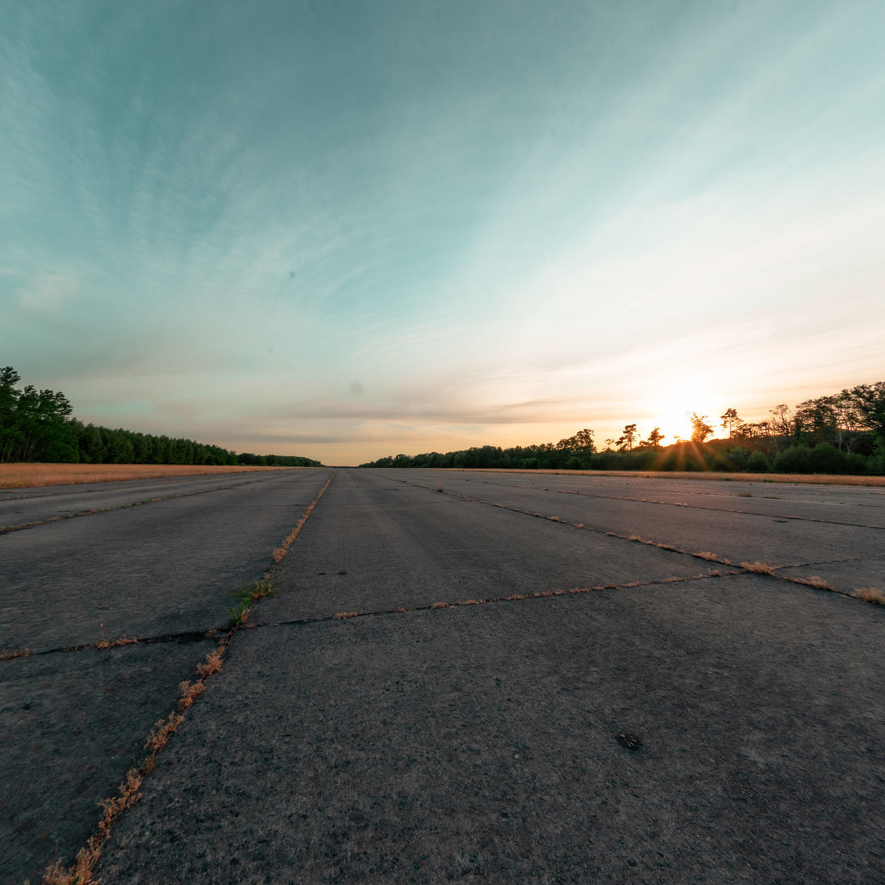 EMPTY ROAD AGAINST SKY AT SUNSET