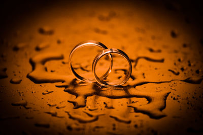 Close-up of wedding rings on wet table