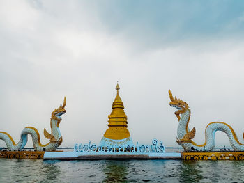 Sculpture of building against cloudy sky