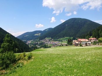 Scenic view of green landscape and mountains against sky