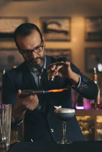 Male bartender preparing cocktail at bar counter