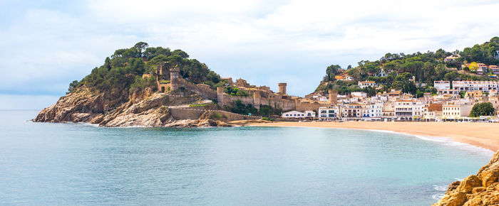 Scenic view of sea by city against sky