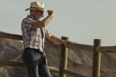 Portrait of adult man in sun hat and shirt in desert