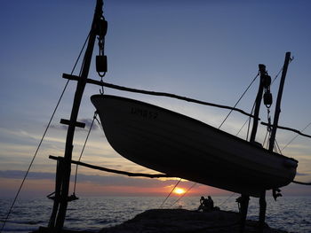 Silhouette boat sailing on sea against clear sky
