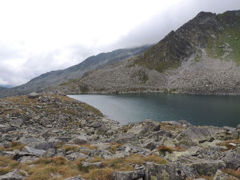 Scenic view of lake by mountains against sky