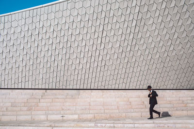 Full length of man walking against wall