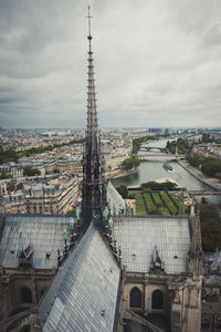 Spire of notre dame de paris against cloudy sky