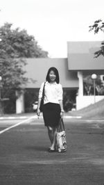 Portrait of woman standing on road in city