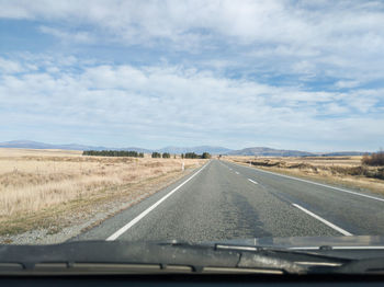 Road against sky seen through car windshield