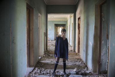 Portrait of woman standing in corridor of abandoned building