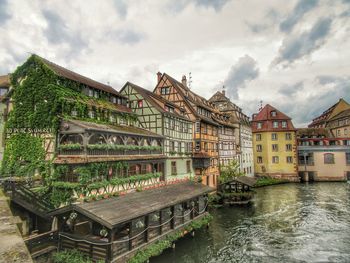 Built structure by river against sky