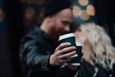 Midsection of man holding coffee cup