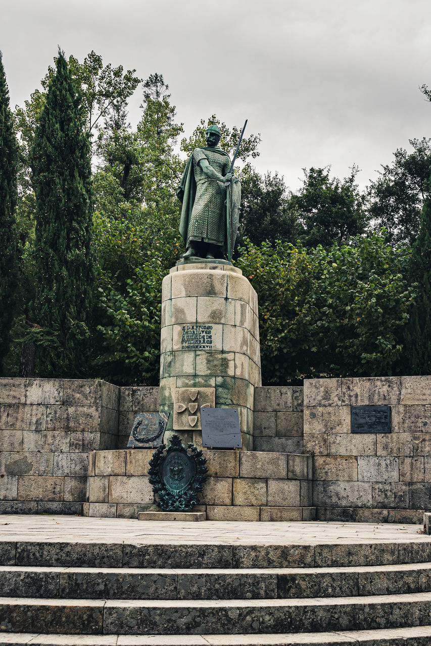 LOW ANGLE VIEW OF STATUE AGAINST TREES AND PLANTS