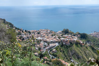 High angle view of townscape by sea against sky