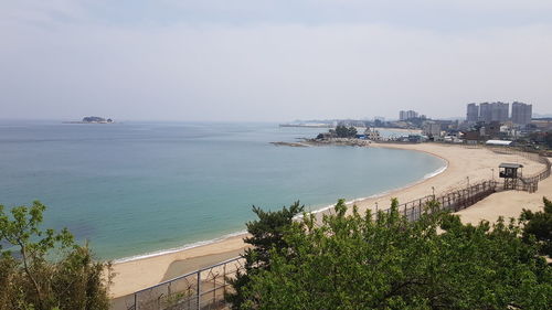 High angle view of sea and buildings against sky