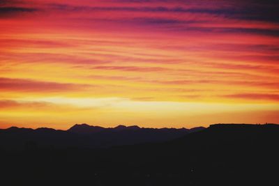 Scenic view of silhouette mountains against sky at sunset