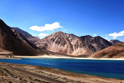 Scenic view of lake and mountains against blue sky