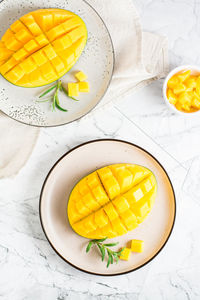 Ripe sliced mangoes on plates on the table. tropical fruit. top and vertical view