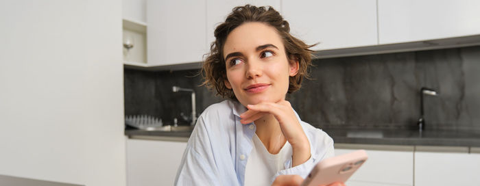 Portrait of young woman standing at home