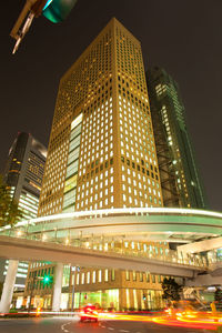 Low angle view of illuminated buildings against sky at night