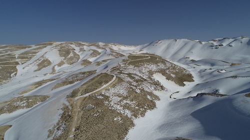 Scenic view of snowcapped mountains against clear sky