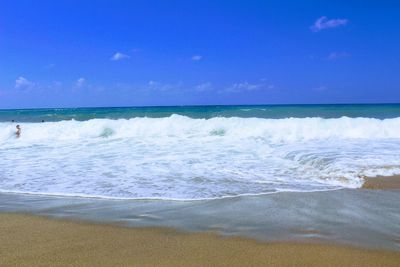 Scenic view of beach against blue sky