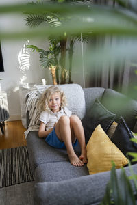 Smiling blond girl on sofa in living room