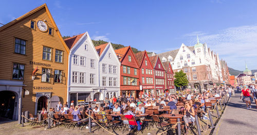 People on street against buildings in city