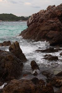 Rock formation on beach against sky