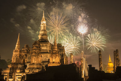 Low angle view of firework display against sky at night