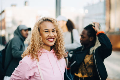 Portrait of smiling woman with friends in city