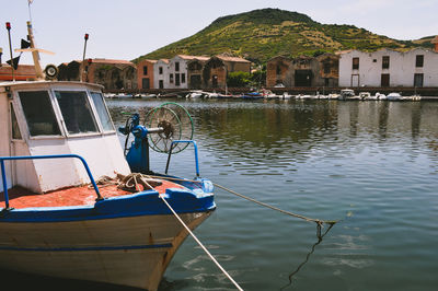 Fishing boats moored in lake against sky