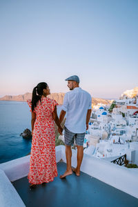 Rear view of couple standing against sky