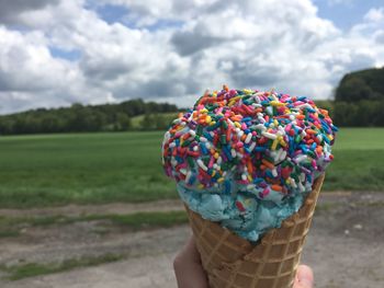 Close-up of ice cream cone against sky