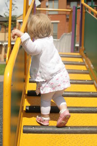 Rear view of girl walking on staircase