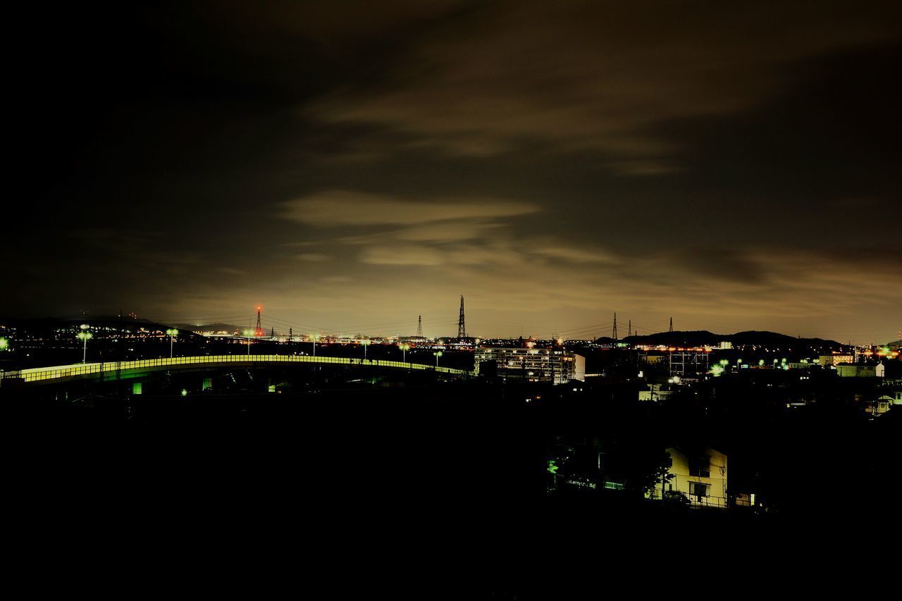 ILLUMINATED CITY AGAINST CLOUDY SKY