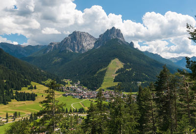 Panoramic view of vigo di fassa touristic mountain city on summer day of sun, trentino, italy