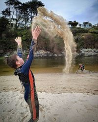 Rear view of woman standing at beach