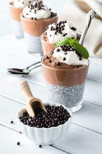 Chocolate chia pudding parfaits with a bowl of chocolate quinoa puffs in front.